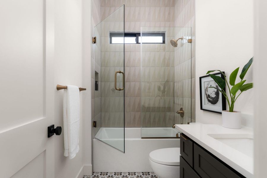 A well-appointed bathroom offers a convenient shower-tub combination and a single vanity.