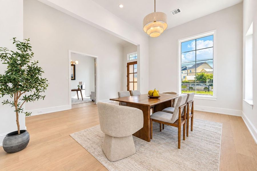 Light-filled dining area featuring French Oak floors, soaring ceilings, and a statement designer chandelier. Large windows bring in abundant natural light, while the open layout provides an elegant setting for intimate dinners or entertaining family and friends. Light-filled dining area featuring French Oak floors, soaring ceilings, and a statement designer chandelier. Large windows bring in abundant natural light, while the open layout provides an elegant setting for intimate dinners or entertaining family and friends.