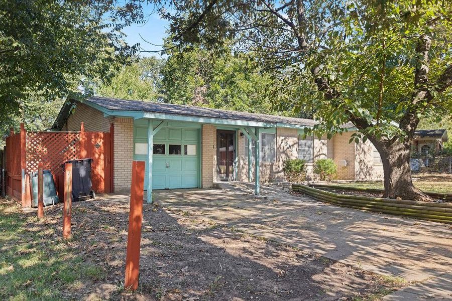 View of front facade with concrete driveway, brick siding, and an attached garage