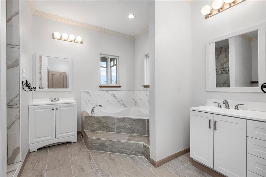 Primary bath features a jetted tub, double vanities and walk-in showers