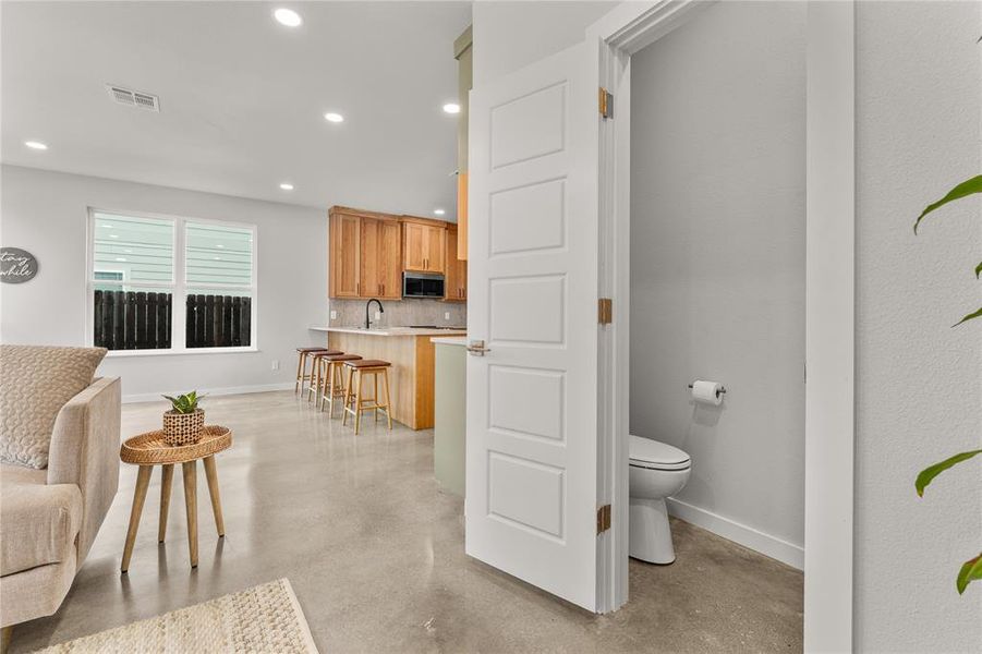 Bathroom with concrete floors, decorative backsplash, and recessed lighting Bathroom with concrete floors, decorative backsplash, and recessed lighting