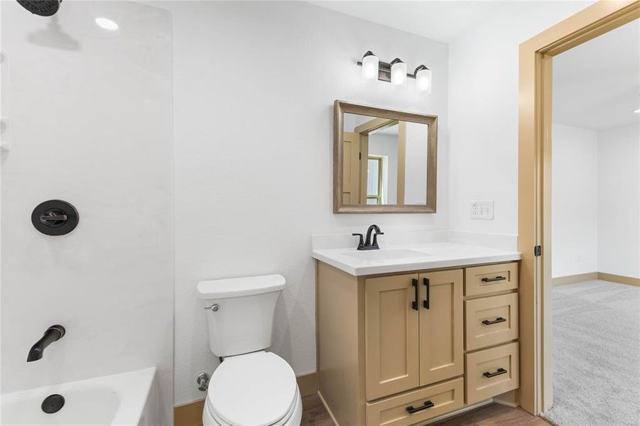 Full bathroom with vanity, shower / tub combination, and light wood-style flooring