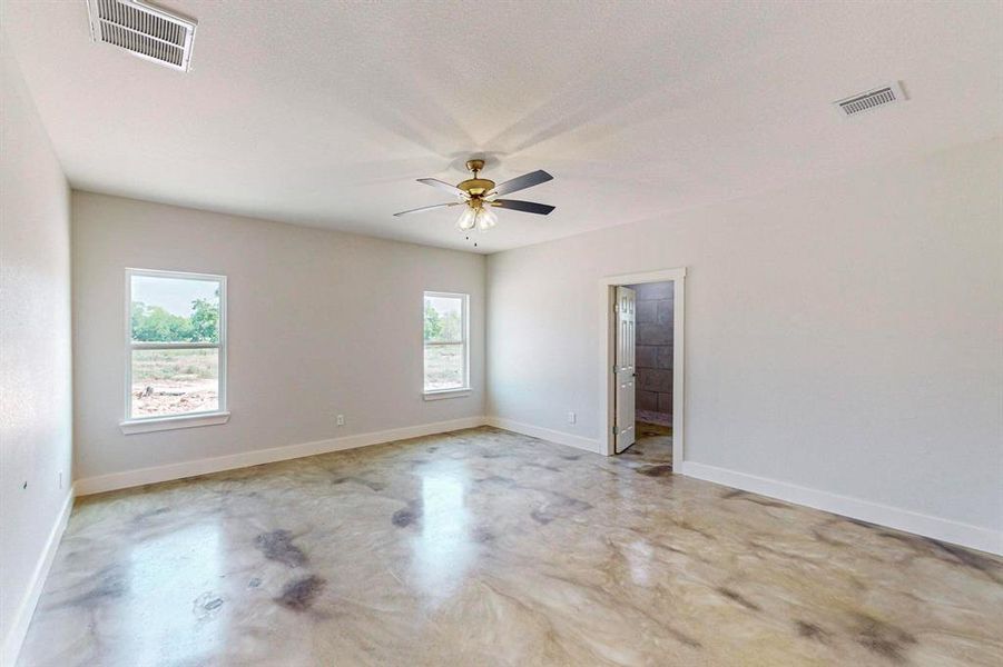 Spare room featuring ceiling fan, a healthy amount of sunlight, and a textured ceiling