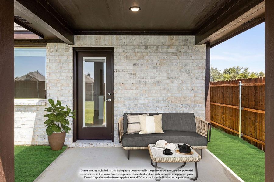 Covered back patio with outdoor sofa, coffee table, brick wall, and glass door entry to home