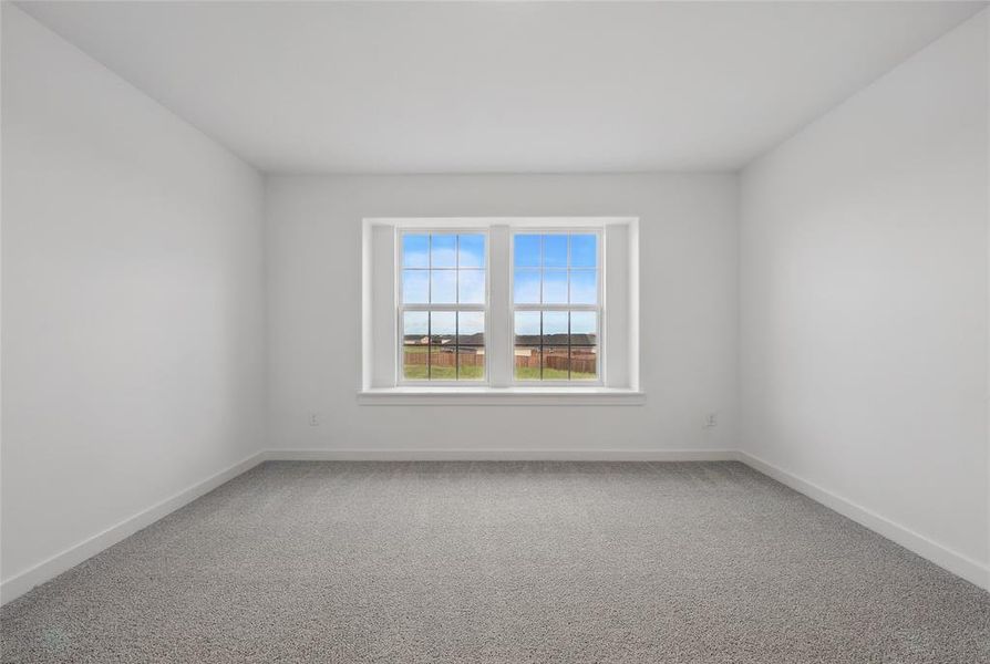 Spare room with light colored carpet and baseboards