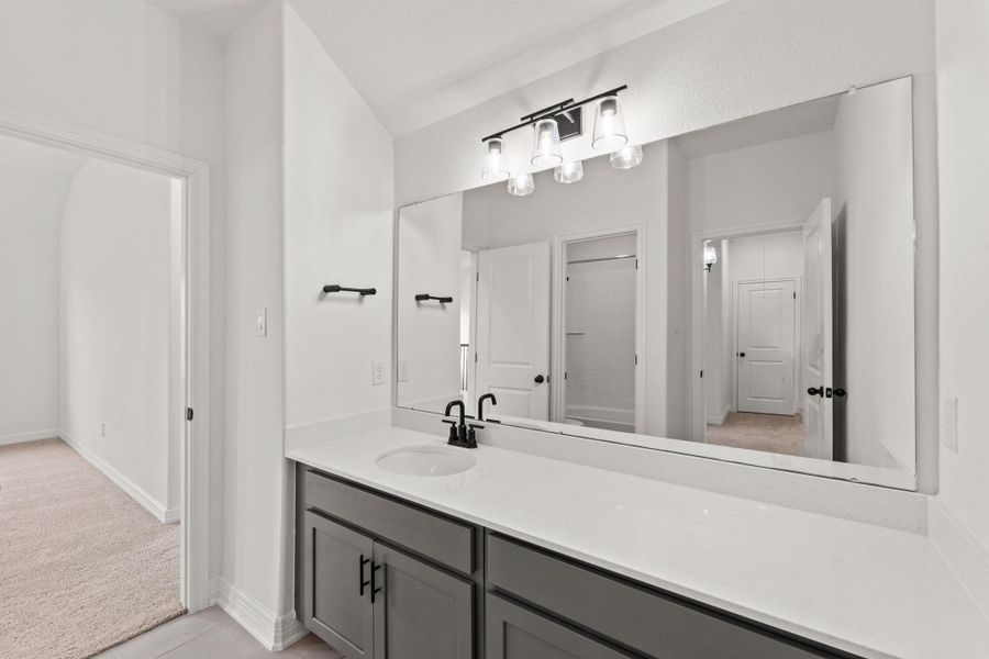 The secondary bath features tile flooring, white cabinetry and light countertops and a shower/tub combo. Perfect for accommodating any visiting family and friends.