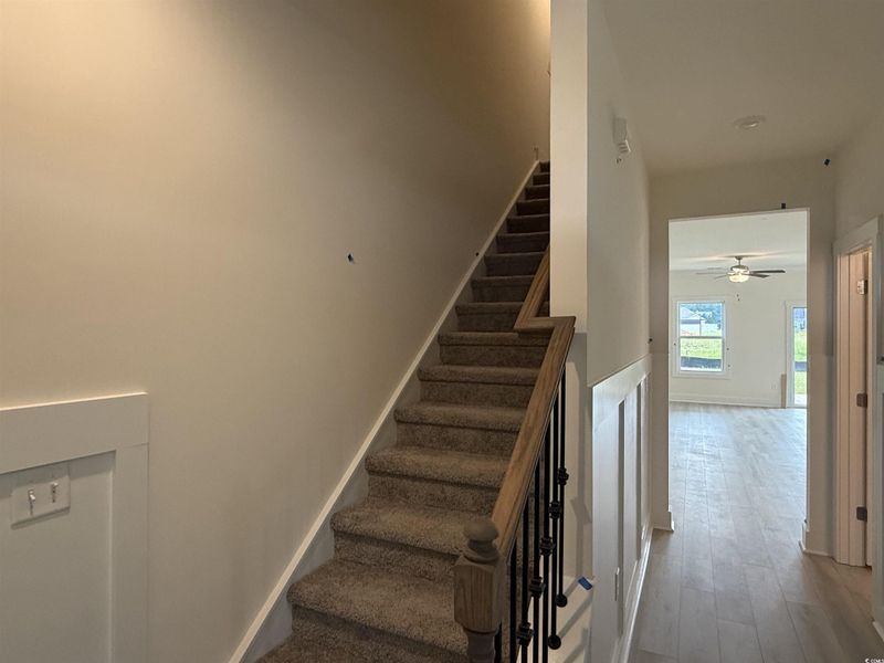 Staircase with ceiling fan and wood finished floors