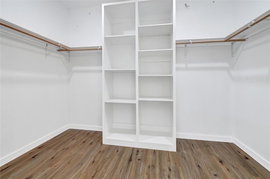 Expansive walk-in closet with built-in shelving and ample storage. Expansive walk-in closet with built-in shelving and ample storage.
