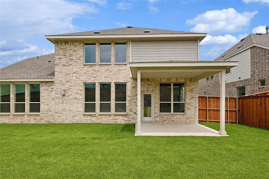 Rear view of property featuring a patio and a lawn