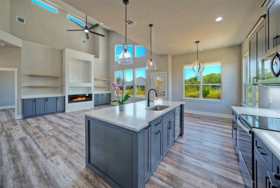High ceilings and tall windows frame the open-concept layout centered around a spacious island. High ceilings and tall windows frame the open-concept layout centered around a spacious island.