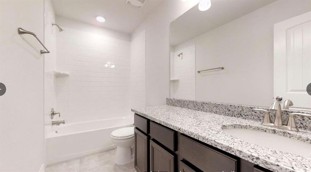 Bathroom featuring toilet, vanity, washtub / shower combination, and tile patterned floors