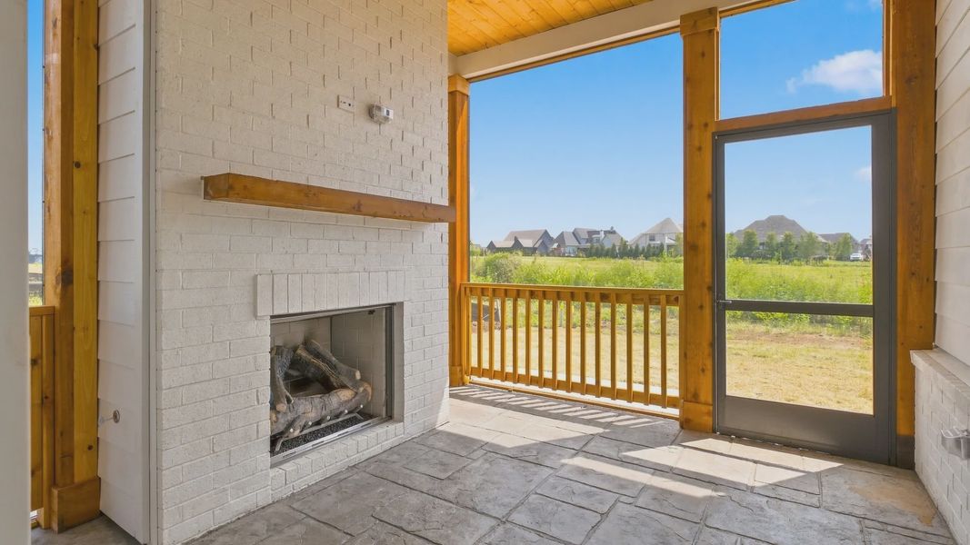 Screened-in backyard porch living area with fireplace allowing for outdoor activities.