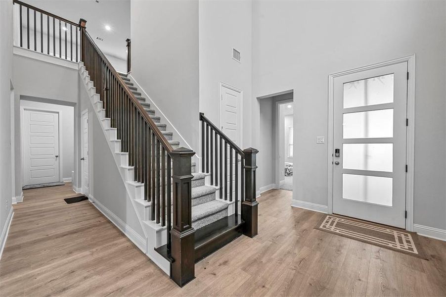 Entrance foyer featuring light wood flooring and a high ceiling