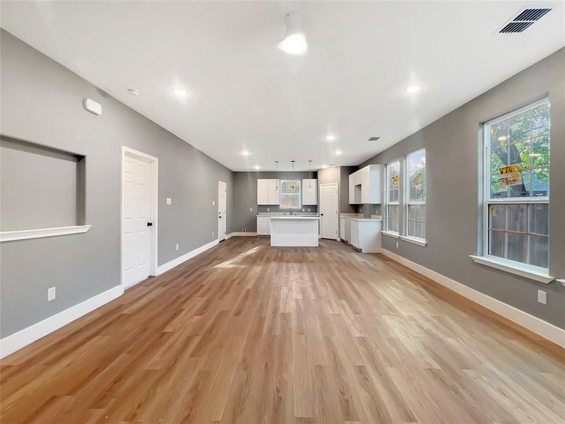 Unfurnished living room featuring sink and light hardwood / wood-style flooring