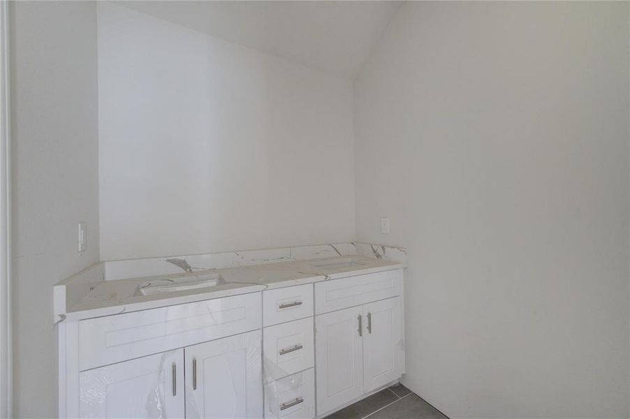 The vanity area, equipped with elegant cabinetry and countertops, provides ample space for daily routines. Its minimalist design ensures it complements any decor style, making it a versatile addition to this unfinished bathroom. **This image is from another Saratoga Home - Artemis floorplan.**