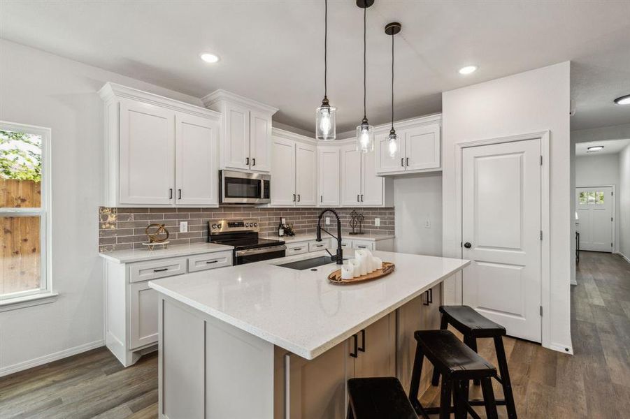 Kitchen with dark wood-type flooring, white cabinetry, and stainless steel appliances