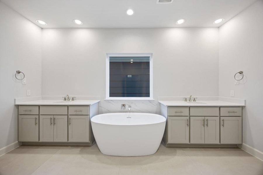 Step into an oasis featuring a vessel tub set between dual vanities, framed by custom wood cabinets and quartz countertops, for an unwavering indulgence. Step into an oasis featuring a vessel tub set between dual vanities, framed by custom wood cabinets and quartz countertops, for an unwavering indulgence.