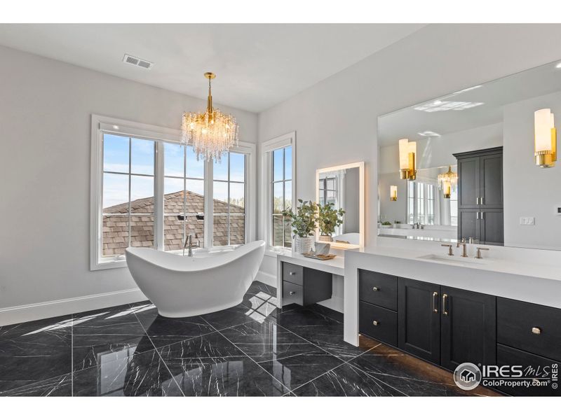 Primary bath with large soaking tub, seated makeup mirror, heated tile floor, and under cabinet lighting