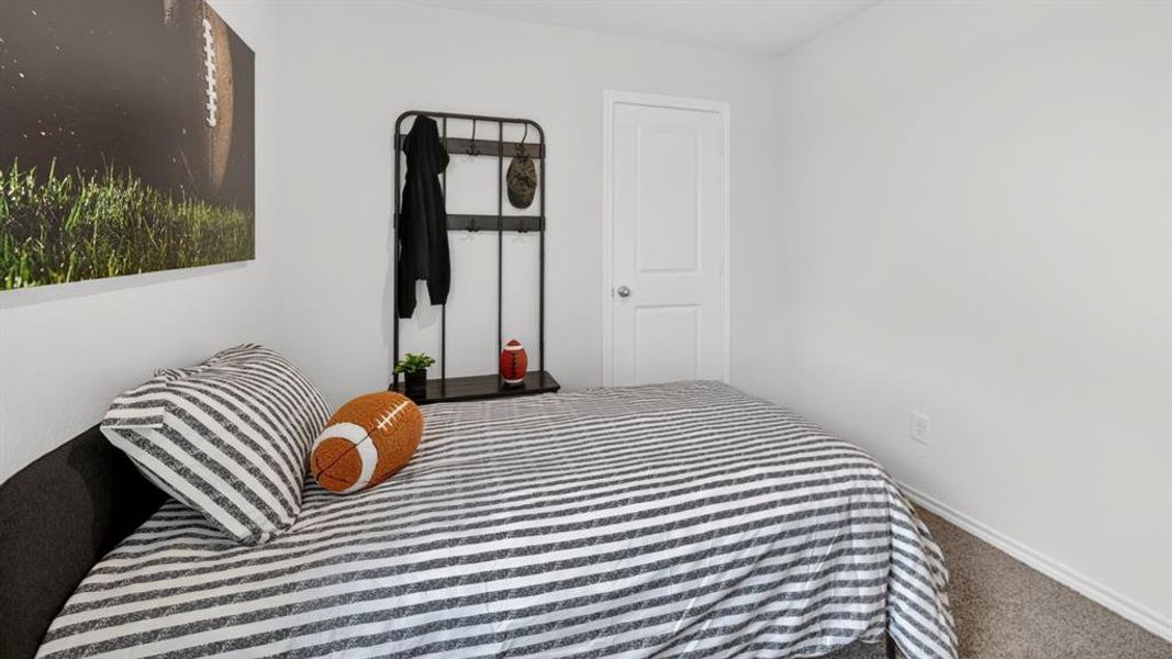Bedroom featuring light gray walls, gray carpet, white baseboards, and a white two-panel door with a round doorknob Bedroom featuring light gray walls, gray carpet, white baseboards, and a white two-panel door with a round doorknob