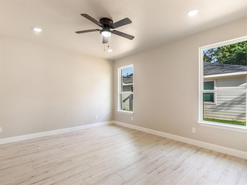 Spare room with light wood-style flooring, ceiling fan, and recessed lighting Spare room with light wood-style flooring, ceiling fan, and recessed lighting