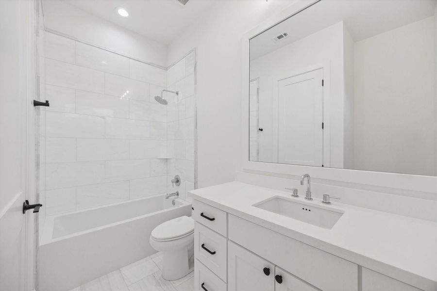 Crisp tile surrounds and a tub and shower combination create a clean, functional bath designed for daily use. A generous vanity and neutral finishes allow the space to serve secondary bedrooms or guests with ease and longevity. Crisp tile surrounds and a tub and shower combination create a clean, functional bath designed for daily use. A generous vanity and neutral finishes allow the space to serve secondary bedrooms or guests with ease and longevity.
