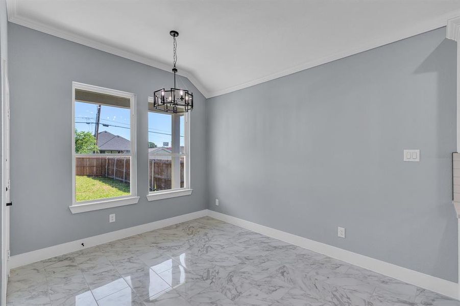 Empty room featuring an inviting chandelier, crown molding, light tile floors, and lofted ceiling