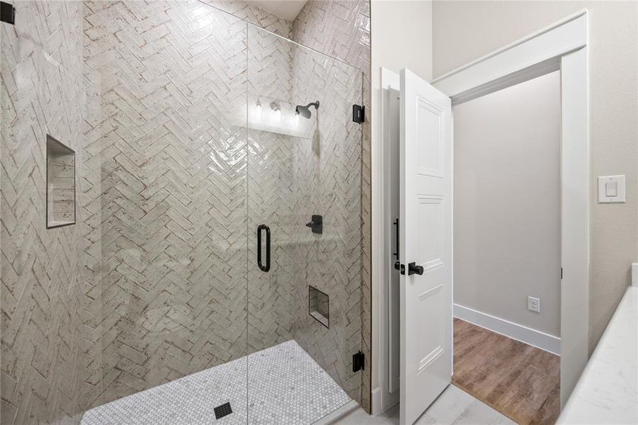 Full bath with a stall shower and wood finished floors