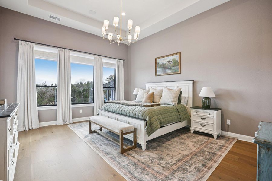 Designed as a personal sanctuary, the primary suite is highlighted by an elegant tray ceiling and large windows that welcome abundant natural light.