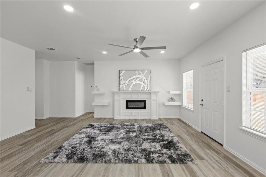 Living area featuring light wood-type flooring, visible vents, a healthy amount of sunlight, and ceiling fan