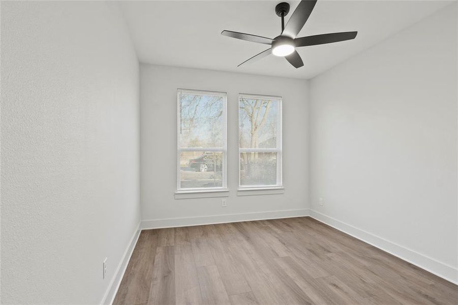 Spare room with ceiling fan, baseboards, and wood finished floors