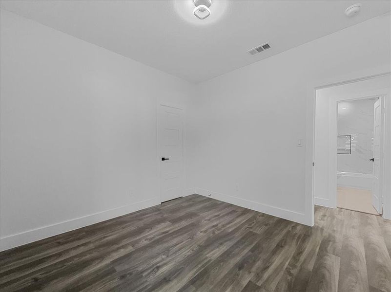 Spare room featuring dark wood-style flooring and baseboards Spare room featuring dark wood-style flooring and baseboards