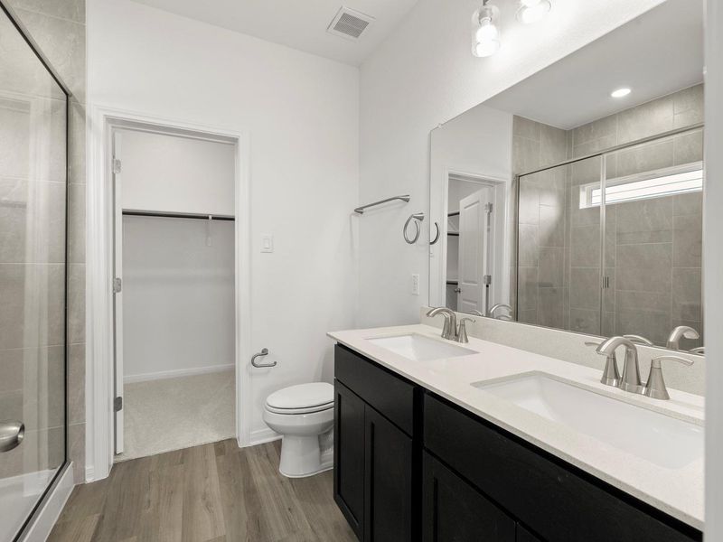 Dual vanity with bright lighting and modern fixtures provides convenience in this bathroom.