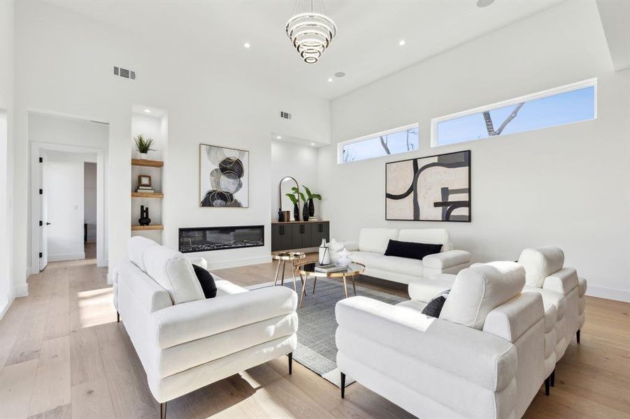 Living room featuring a towering ceiling and light wood-type flooring