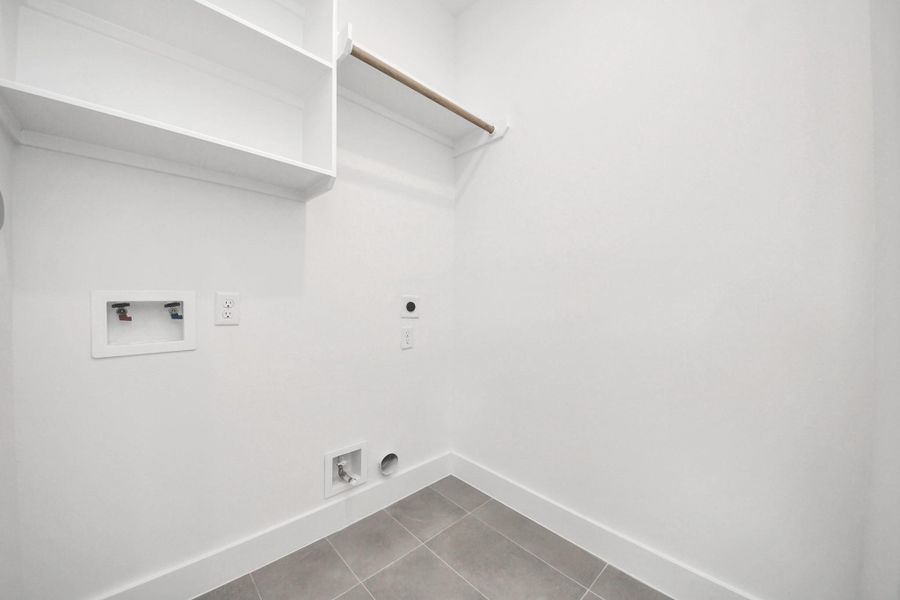 This bright and spacious laundry room offers ample shelving and modern hookups, ensuring a streamlined and efficient laundry experience.