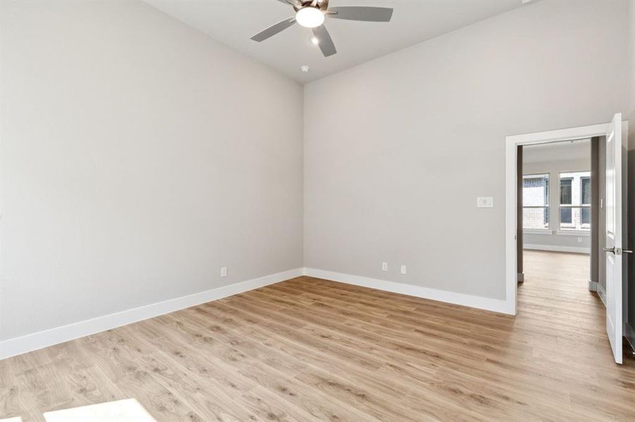 Empty room with light wood finished floors and a ceiling fan