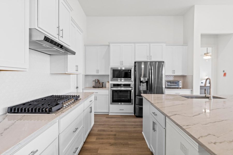 Notice the stainless steel gas cooktop and built in oven and microwave.