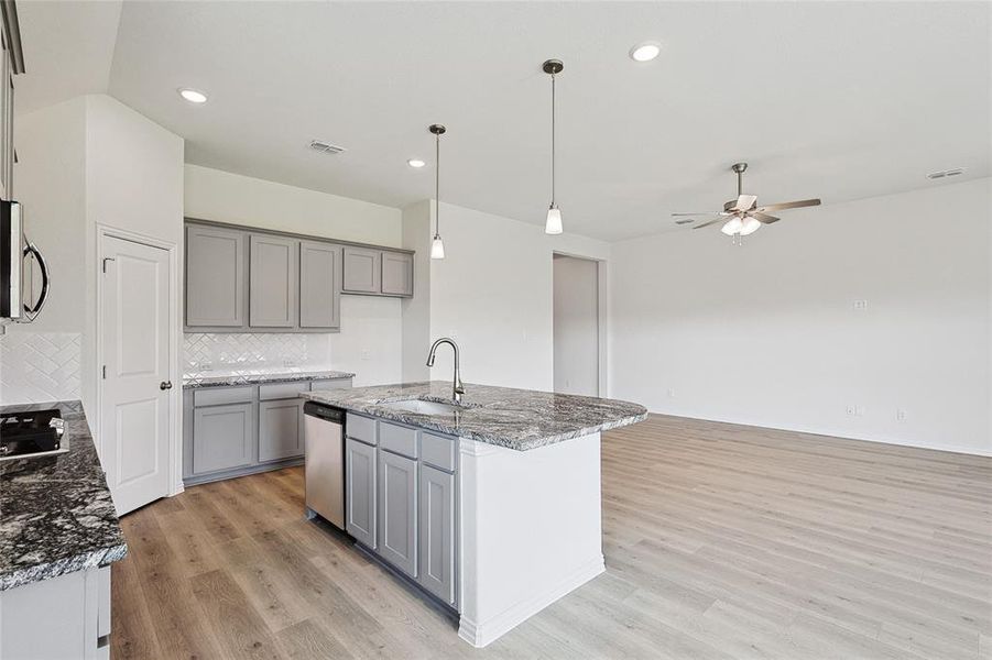 Kitchen with tasteful backsplash, light hardwood / wood-style flooring, sink, ceiling fan, and appliances with stainless steel finishes