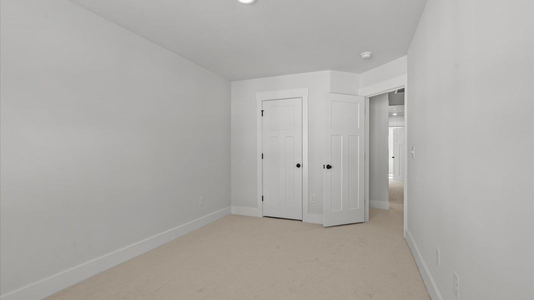 First-class secondary bedroom with comfortable carpeted flooring and generous closet space