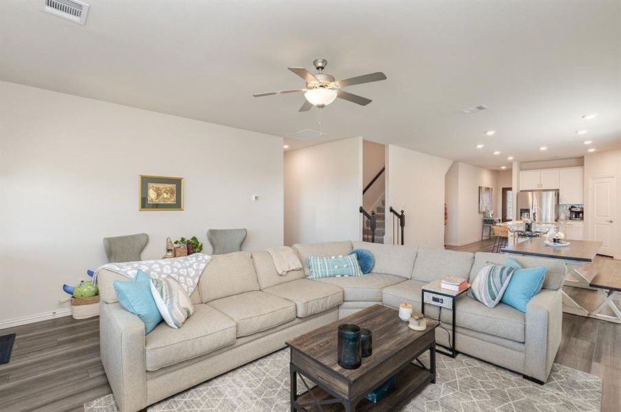 Living room featuring wood-type flooring and ceiling fan