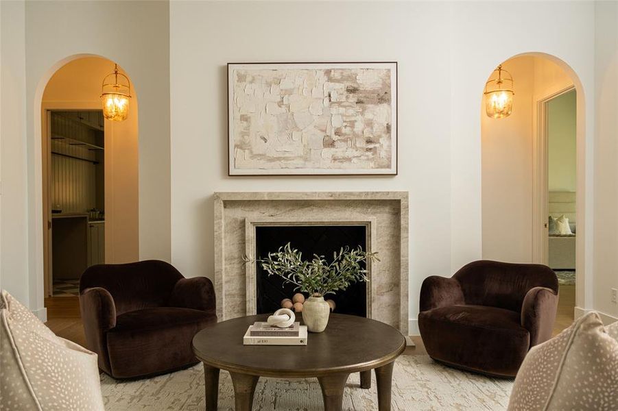 Living area featuring arched walkways and wood finished floors