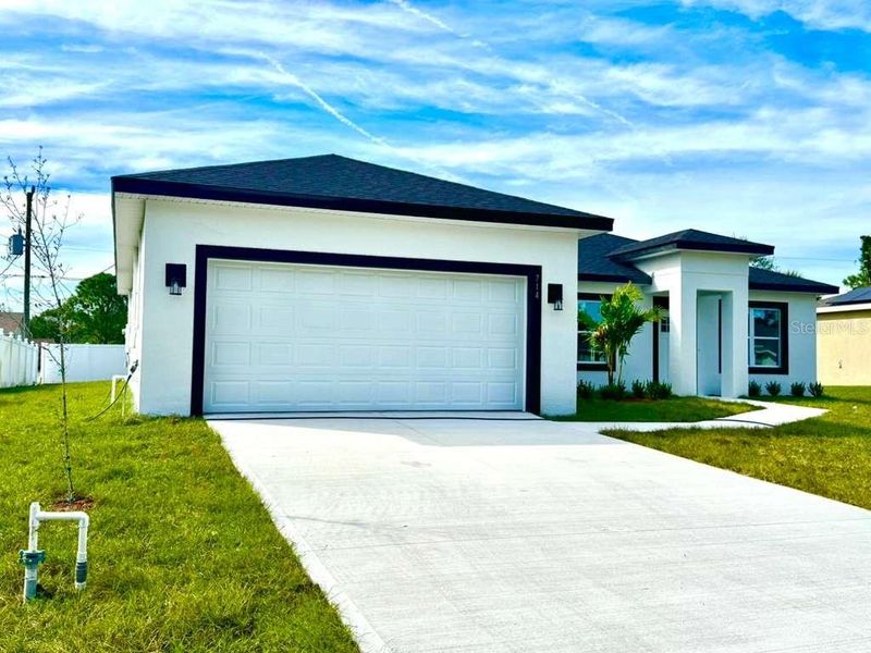 Front exterior of a new home in , Palm Bay, FL, highlighting curb appeal (Image 1).