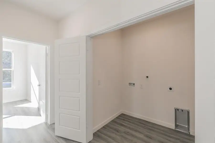 Clothes washing area featuring hookup for a washing machine, baseboards, electric dryer hookup, and wood finished floors