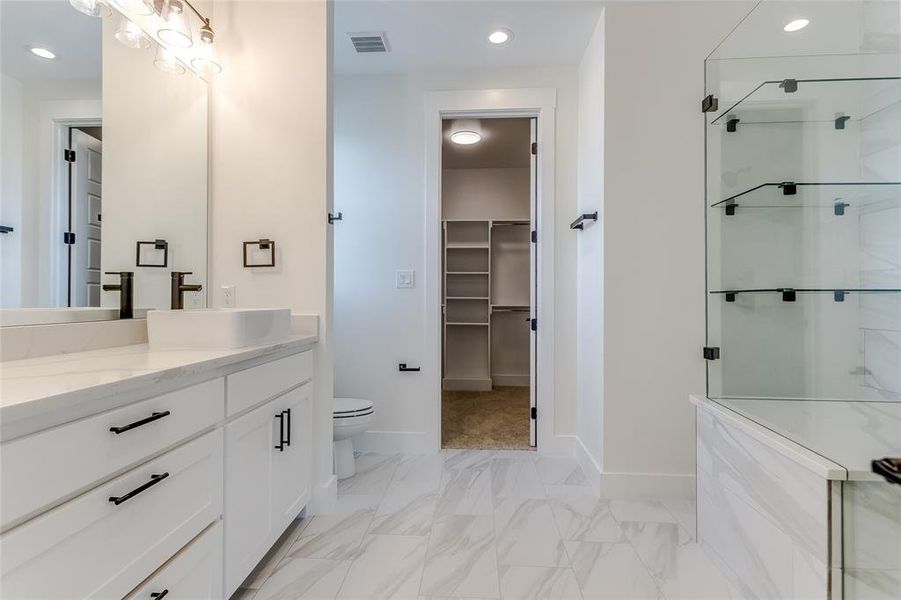 Bathroom with vanity, toilet, and a shower with shower door