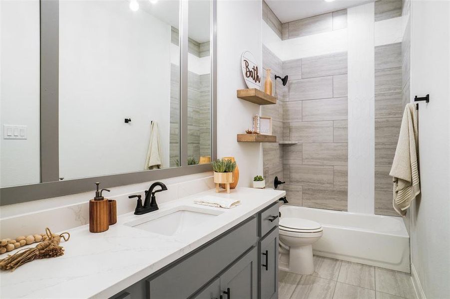 Full bathroom with toilet, vanity, and tiled shower / bath