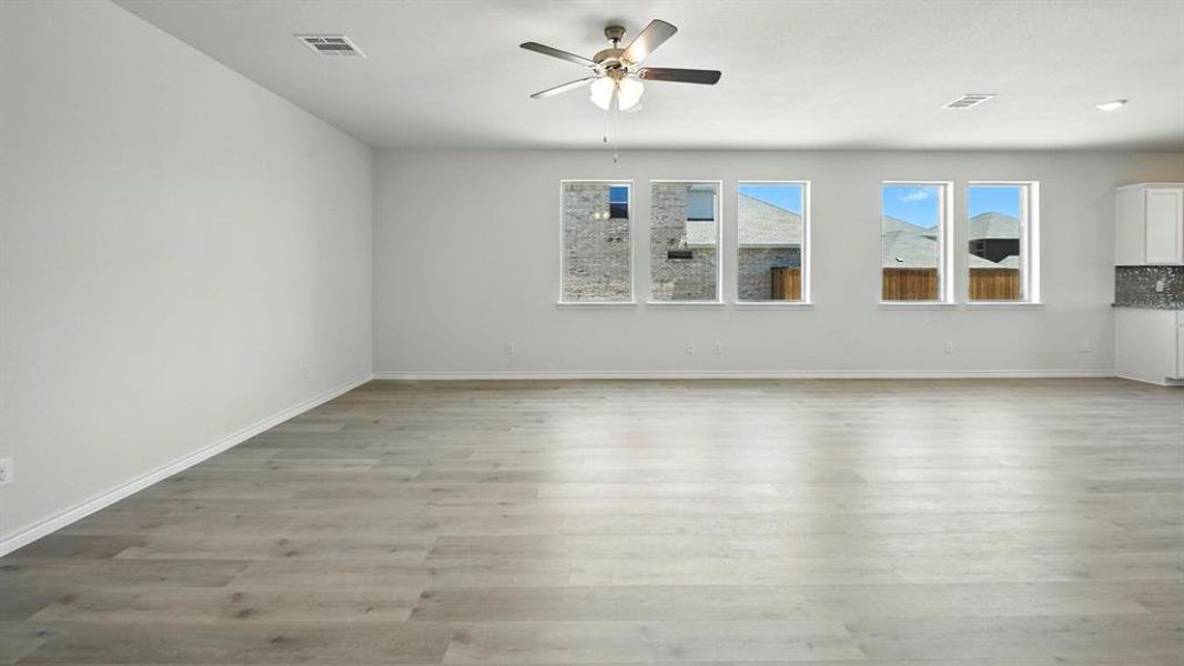 Unfurnished living room with light wood-style floors and a ceiling fan