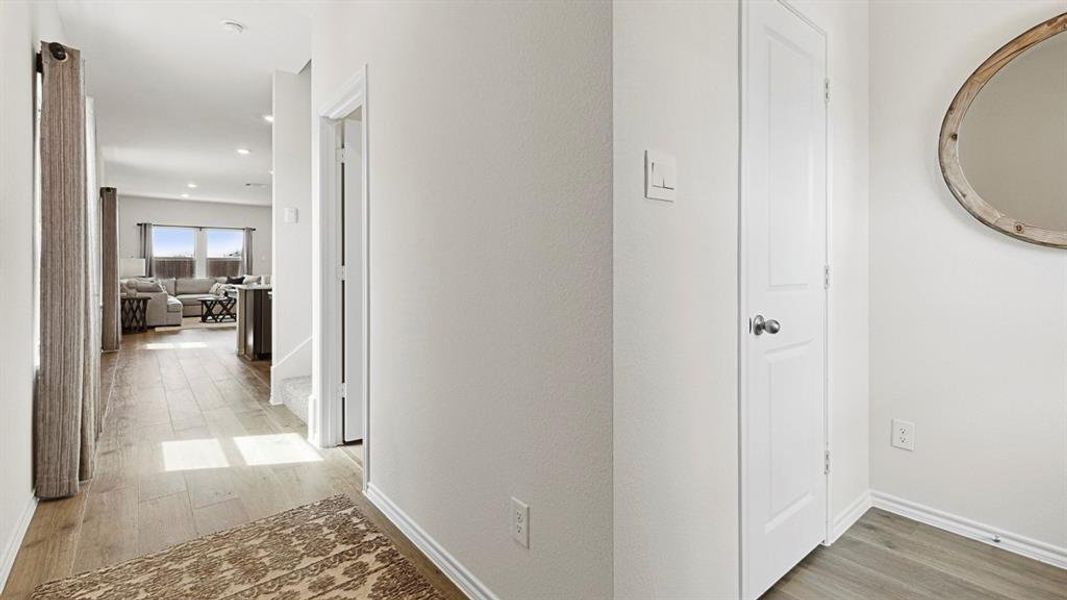 The property features light wood flooring, white walls, and a white paneled door