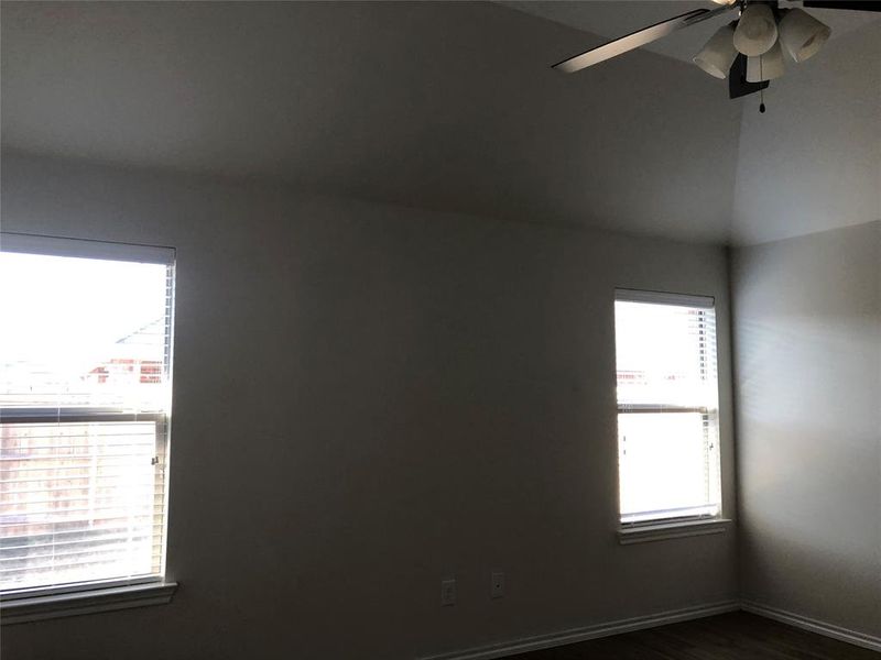 Empty room with ceiling fan and dark wood-type flooring