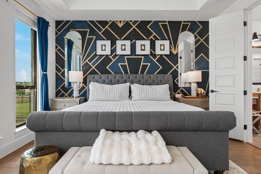 Luxurious sleeping quarters feature a deep tray ceiling and rich hardwood flooring, with vibrant accent wall art. Luxurious sleeping quarters feature a deep tray ceiling and rich hardwood flooring, with vibrant accent wall art.
