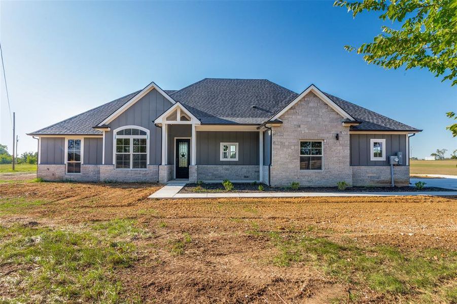 Craftsman house with board and batten siding, a shingled roof, covered porch, and a front lawn Craftsman house with board and batten siding, a shingled roof, covered porch, and a front lawn