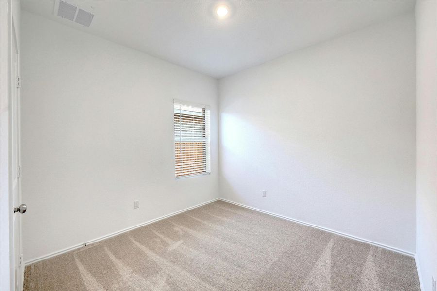 Empty room featuring light carpet